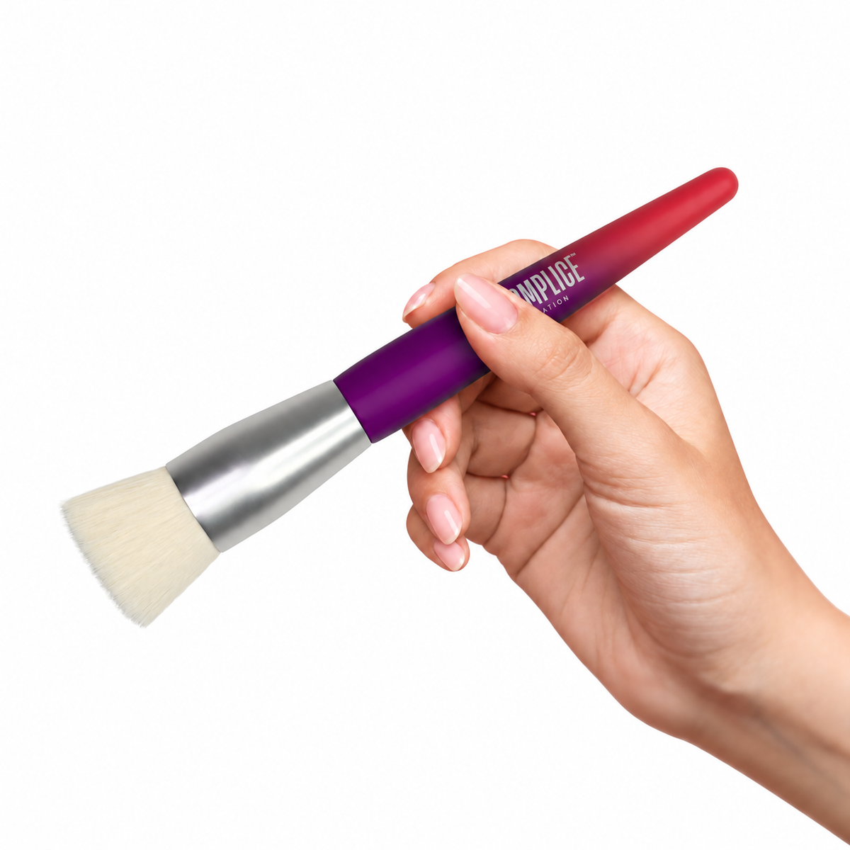 Complice Nation® foundation brush held in a hand with a pale pink manicure on a white background